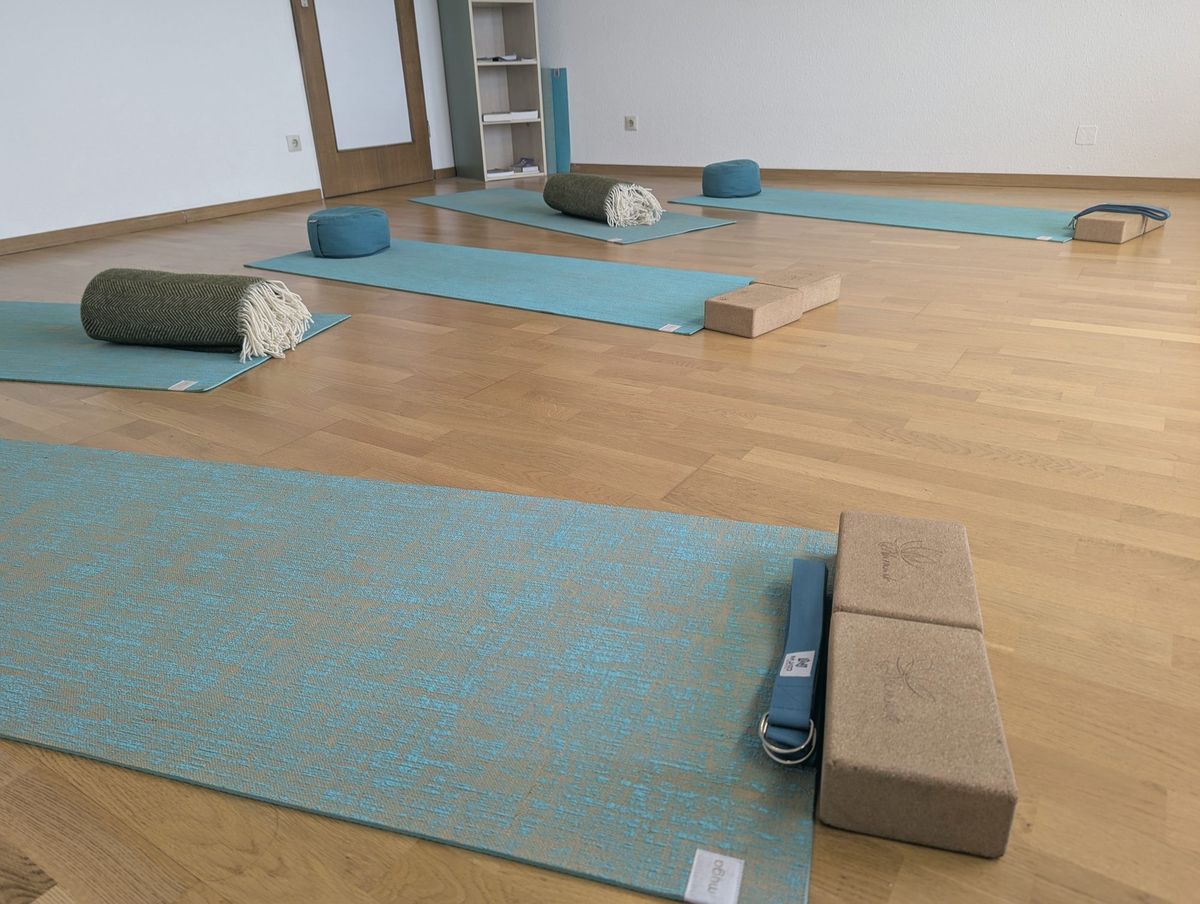 Teal mat with cork blocks, strap and bolster ready for class